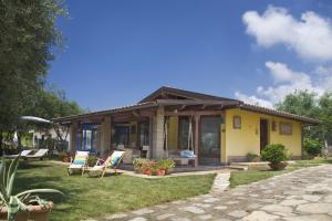 una pequeña casa amarilla con sillas y patio en Villa Michela tra Cielo e Mare, en Gaeta
