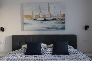 um quarto com uma cama com uma pintura de veleiros em Sol Insula em Murter