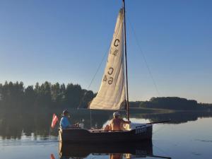 two people on a sail boat on a lake at Meiranu krasts in Bērzgale