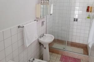 ein weißes Bad mit einem Waschbecken und einer Dusche in der Unterkunft Central and quiet apartment in Cochabamba in Cochabamba