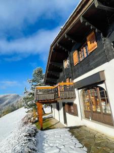 a building with a balcony in the snow at Très beau chalet familial - Vue superbe ! Plein sud in La Clusaz