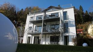 ein weißes Gebäude mit Balkon auf der Seite in der Unterkunft Blockhaus Säuling - Haus Elise Apartments in Füssen
