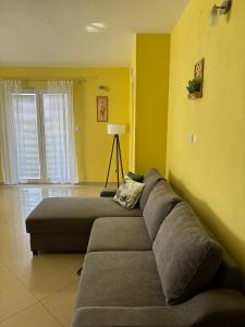 ein Wohnzimmer mit einem Sofa und einer gelben Wand in der Unterkunft Apartment Alena 1 i 2 in Bibinje