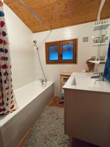 a bathroom with a tub and a sink and a bath tub at Très beau chalet familial - Vue superbe ! Plein sud in La Clusaz