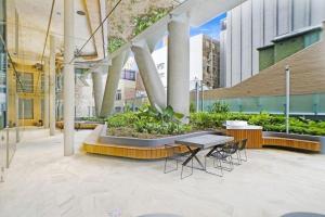 um pátio com uma mesa e cadeiras num edifício em Sydney CBD Luxury Furnished Apartment & City Views em Sidney