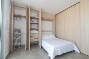 a small bedroom with a bed and a closet at Beachside Bliss: Salguero Suites in Gaira