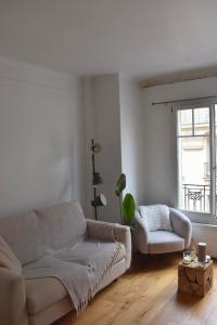 a white living room with a couch and a chair at Louis’ haven in Paris