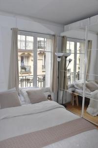 a bedroom with a bed and a large window at Louis’ haven in Paris