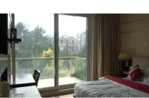 a room with a bed and a large window at Rao Regency in Gurgaon