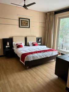 a bedroom with a large bed with red pillows at Rao Regency in Gurgaon