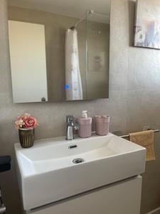 uma casa de banho com um lavatório branco e um espelho. em CASA MALENI em Altea