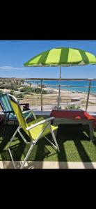 duas cadeiras e uma mesa e um guarda-sol na praia em Apparemment grand standing pied dans l'eau em Douane