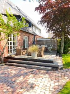 a brick house with a patio with two benches at Tiiner in List