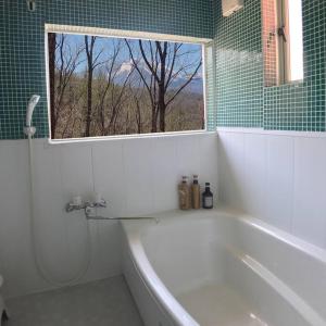 baño con bañera blanca y ventana en Kitakaruizawa Morino Bessou NO3, en Tsumagoi