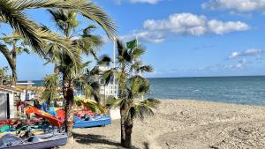 plaża z palmami i zjeżdżalnią wodną w obiekcie Beachfront 1BR apartment in center of MArbella! w Marbelli
