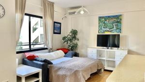 sypialnia z łóżkiem, telewizorem i oknem w obiekcie Beachfront 1BR apartment in center of MArbella! w Marbelli