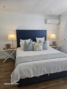 una camera da letto con un grande letto con cuscini e due tavoli di Umhlanga Getaways a Durban