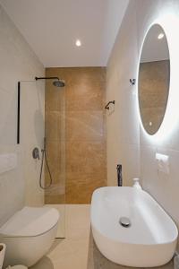W łazience znajduje się umywalka, toaleta i lustro. w obiekcie Villa Xhefri 2 w Sarandzie