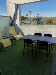 コロンビエールにあるColombiers Escale à la Noria Appartement terrasse 4 personnes et garageのバルコニー(テーブル、椅子付)