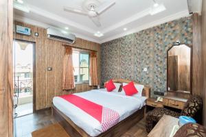 a bedroom with a bed with red pillows at Super Capital O Hotel Bidisha in Digha