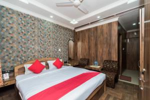 a bedroom with a large bed with red pillows at Super Capital O Hotel Bidisha in Digha