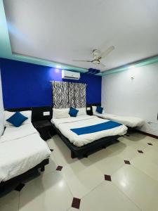 um quarto com 2 camas e uma parede azul em HOTEL SHREE DWARKA em Dwarka