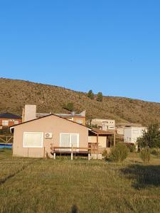 ein Haus auf einem Feld mit einem Hügel im Hintergrund in der Unterkunft Chicharrita in Sierra de la Ventana + 11 Fotos