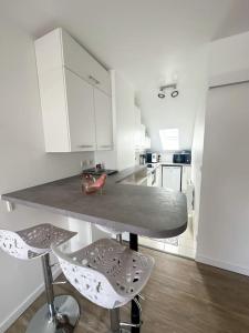 uma cozinha com uma mesa e dois bancos em Charmant studio proche de la gare em Rambouillet