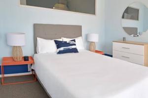 1 dormitorio con 1 cama blanca grande y 2 lámparas en The Bakoven Rock, en Ciudad del Cabo