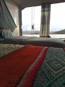 um quarto com 2 camas com um tapete e uma janela em Blue Lake House em Puno