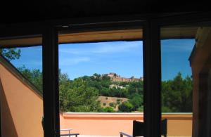 a window with a view of a house at Villa Formica - Vista su Castello di Gradara in Gradara