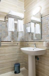 ein Badezimmer mit einem Waschbecken, einem Spiegel und Handtüchern in der Unterkunft El Lotus Building in Kairo