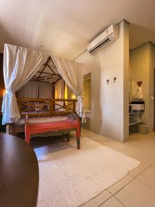 a room with a bed with a canopy and a kitchen at Taj Hotel in Três Lagoas