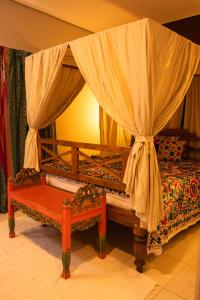 Taj Hotel في تريس لاغواس: غرفة نوم بسرير مع مظلة