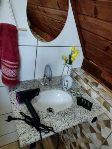 eine Badezimmertheke mit einem Waschbecken und einem Spiegel in der Unterkunft Linda Chacara com 2 Chalés em Boituva in Boituva
