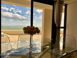 - un bol de fruits sur une table en verre devant une fenêtre dans l'établissement Loddey's Self Catering Apartments - by Beach Collection, à Strand