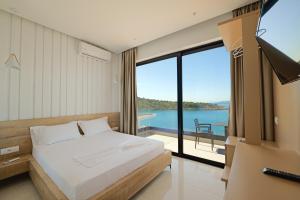 a bedroom with a bed and a view of the water at Villa Xhefri 2 in Sarandë