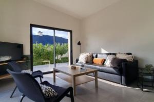 uma sala de estar com um sofá e uma mesa em Maison d'hôtes Proche du port de la Roche-Bernard. em Férel