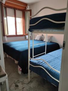 a bedroom with two bunk beds and a window at Completely refurbished flat near the beach in Rosolina Mare