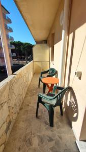 Duas cadeiras e uma mesa numa varanda em Completely refurbished flat near the beach em Rosolina Mare