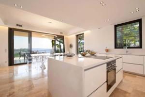 a kitchen with white countertops and a view of the ocean at Villa Sémaphore centre Sainte Maxime in Sainte-Maxime