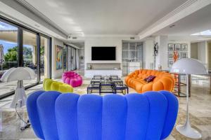 a living room with a blue couch and colorful chairs at Villa Sémaphore centre Sainte Maxime in Sainte-Maxime