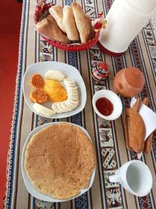 una mesa cubierta con platos de comida y pan en Blue Lake House, en Puno