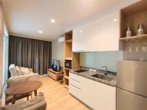 a kitchen with a refrigerator and a table and a couch at 1 Bedroom Pool view at Diamond Resort in Bang Tao Beach