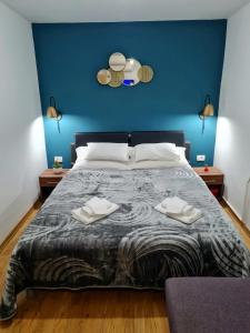 a bedroom with a bed with a blue wall at Inchy Accommodation in Split