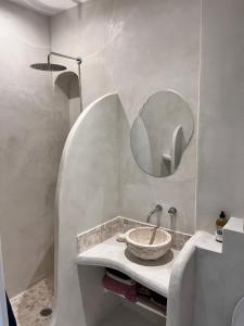 La salle de bains est pourvue d'un lavabo et d'un miroir. dans l'établissement Appartement type Méditerranéen, à Marseille