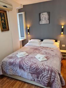 a bedroom with a large bed with two towels on it at Inchy Accommodation in Split