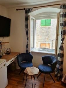 a room with two chairs and a desk and a window at Inchy Accommodation in Split