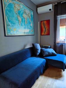 a living room with a blue couch and a map of the world at Euforbia House in Lido di Ostia