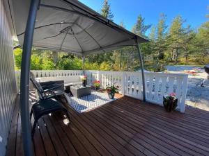 a patio with an umbrella and a chair on a deck at Nordic Villa in Husum